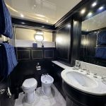 Httpswww Andyquinones Net small luxury bathroom with dark wood cabinets marble countertops double sink toilet and bidet and blue towels on a rack