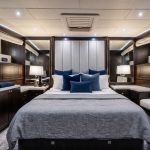 Httpswww Andyquinones Net luxurious yacht cabin with a large bed blue throw pillows and dark wood cabinetry on both sides