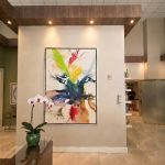 Doctor's office lobby art - https://www.andyquinones.net Httpswww Andyquinones Net interior lobby with a large abstract painting on a beige wall a green potted orchid in the foreground atop a wooden console