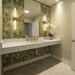 Public Restroom design in doctor's clinic - https://www.andyquinones.net Httpswww Andyquinones Net modern bathroom vanity with tropical leaf wallpaper gold faucet and a large mirror reflecting the ceiling lights